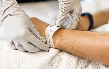 Doctor putting hospital ID bracelet on patient