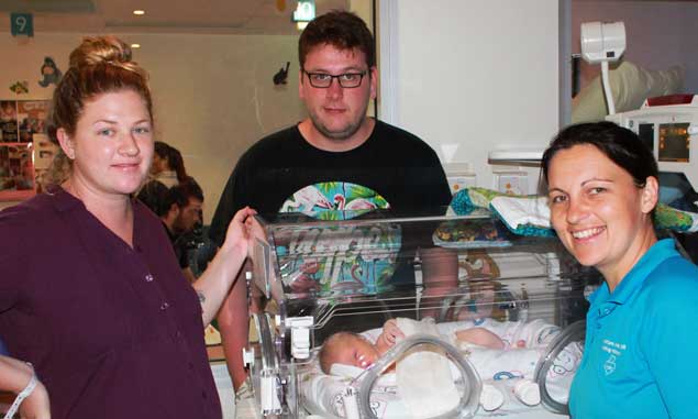 New parents with baby and midwife